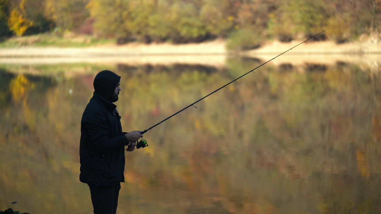 A fisherman fishing in a lake in autumn