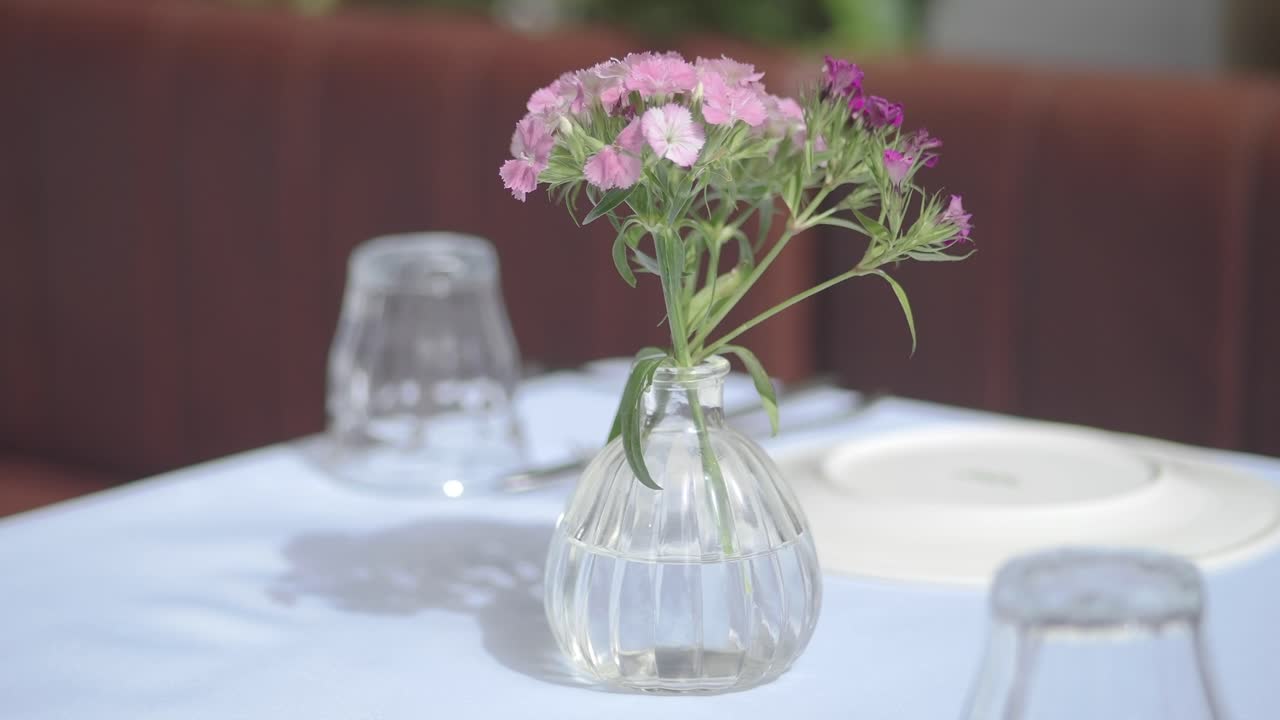 レストランのピンクの花が飾られたエレガントなテーブルセッティング