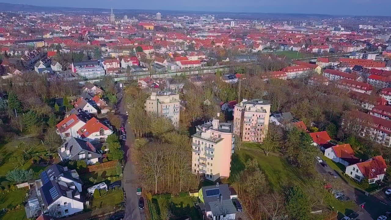 Ujęcie z drona przedstawiające trzy wysokie bloki w oddali i piękną panoramę Osnabrück w tle