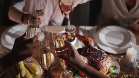 the family clink glasses with sparkling wine over the festive table