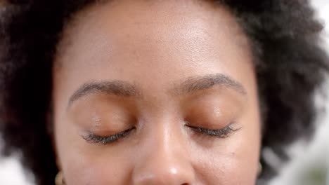 portrait of happy eyes of african american casual businesswoman in office, slow motion