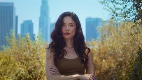 portrait of pretty asian girl in park. relaxed woman standing on nature closeup.