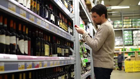 hombre comprando vino en un supermercado