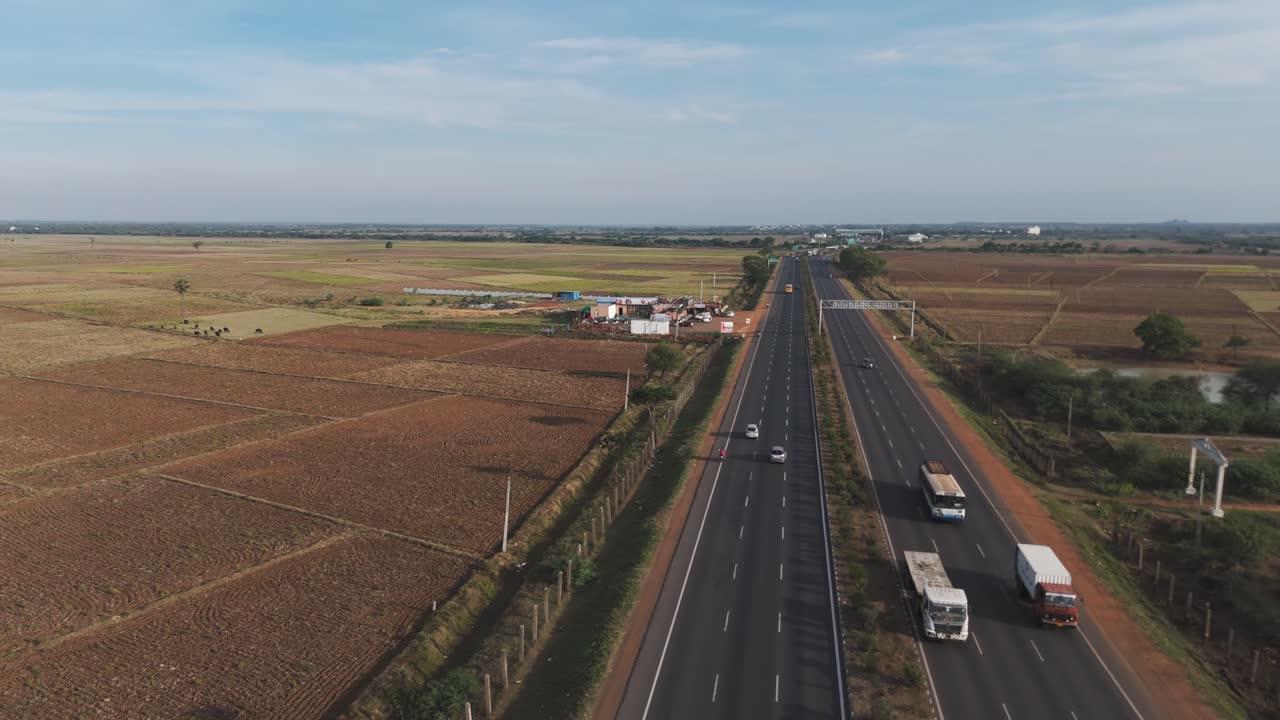 Aerial Drone Shot of Highway with Traffic Passing with Open Field