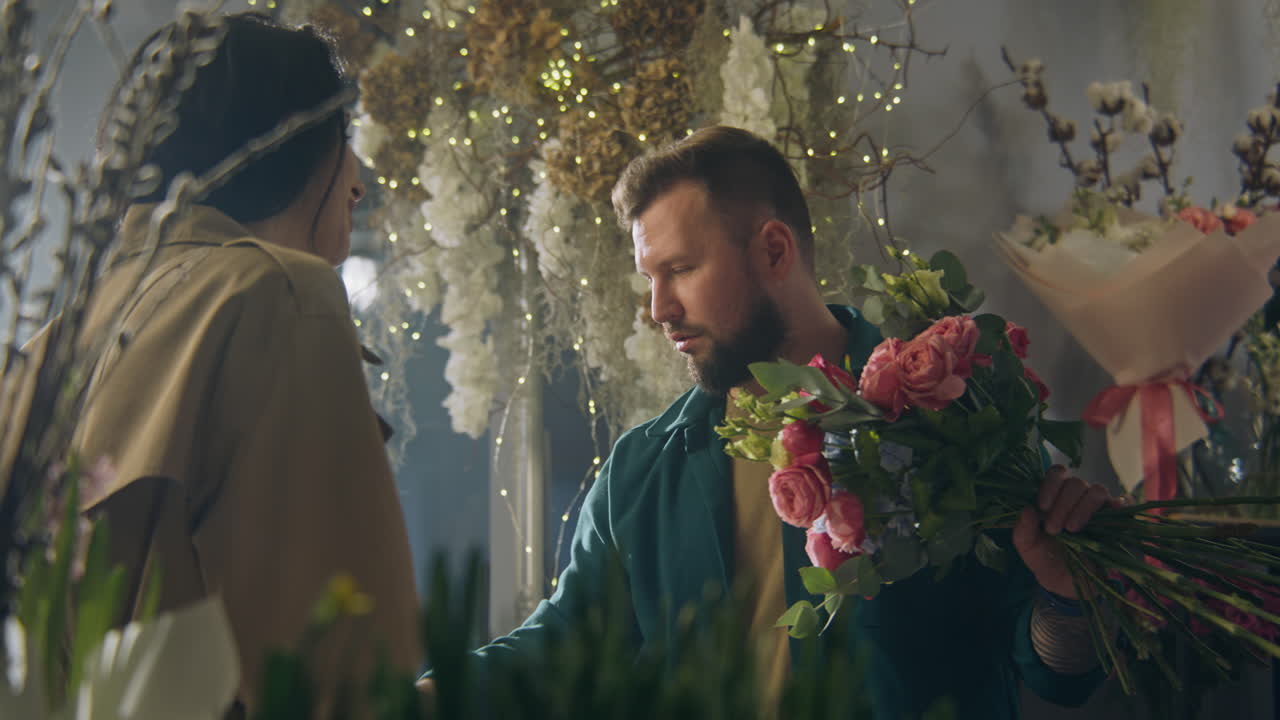 남성 꽃 가게 는 꽃병 에 있는 꽃 을 세고 태블릿 을 사용 하여 주문 을 받는다