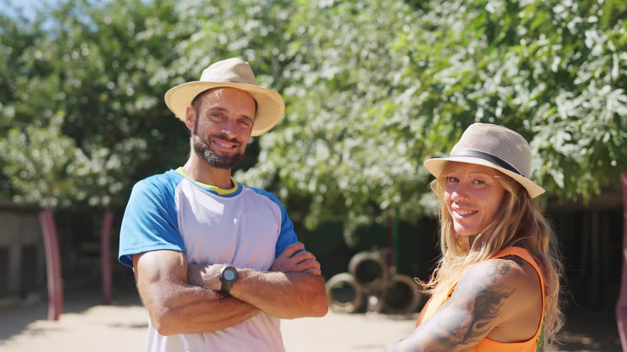 Uomo e donna felici con cappelli che sorridono all'aperto