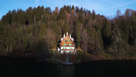 la luz del sol ilumina la mitad superior de la cabaña con vista al lago mirando el reflejo en el agua brillante