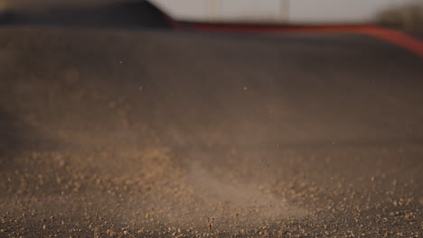 dust particles swirl over a bmx pump track in super slow motion at goes, netherlands