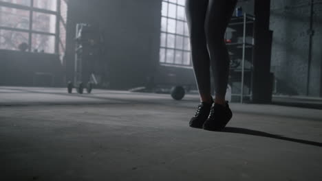 athlete legs jumping on skipping rope in gym. woman doing workout with jump rope