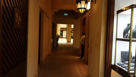 person walking through a hallway with shops