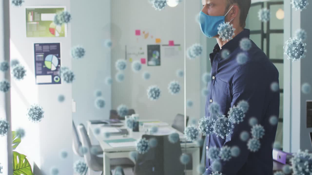 사무실에서 얼굴 마스크를 쓰고 있는 사람 위에 코로나19 세포의 애니메이션