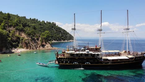 an old wooden ship anchored in a secluded spot, robinson beach, sithonia, greece