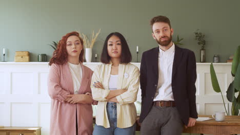 Portrait-Of-Young-Multiethnic-Team-Standing-In-The-Living-Room-And-Looking-At-Camera