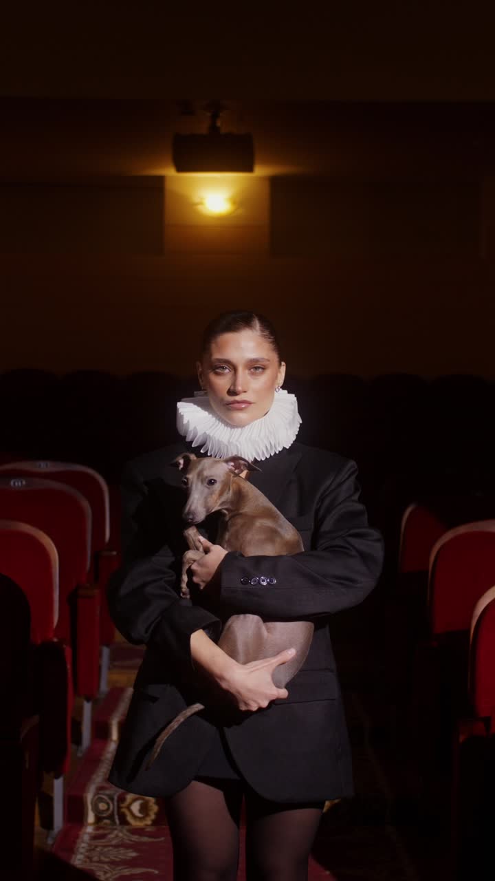 Woman Holding Dog in a Theatre