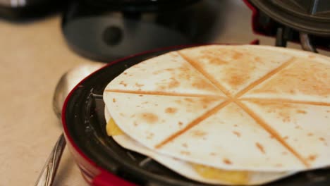 una sartén ancha de 1080p de derecha a izquierda de la cocción de quesadilla