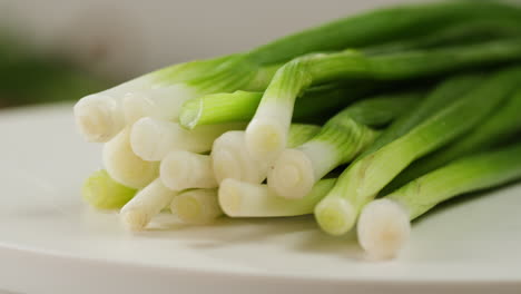 Cutting fresh green onions on a cutting board, close up chef cooking green vegan salad.