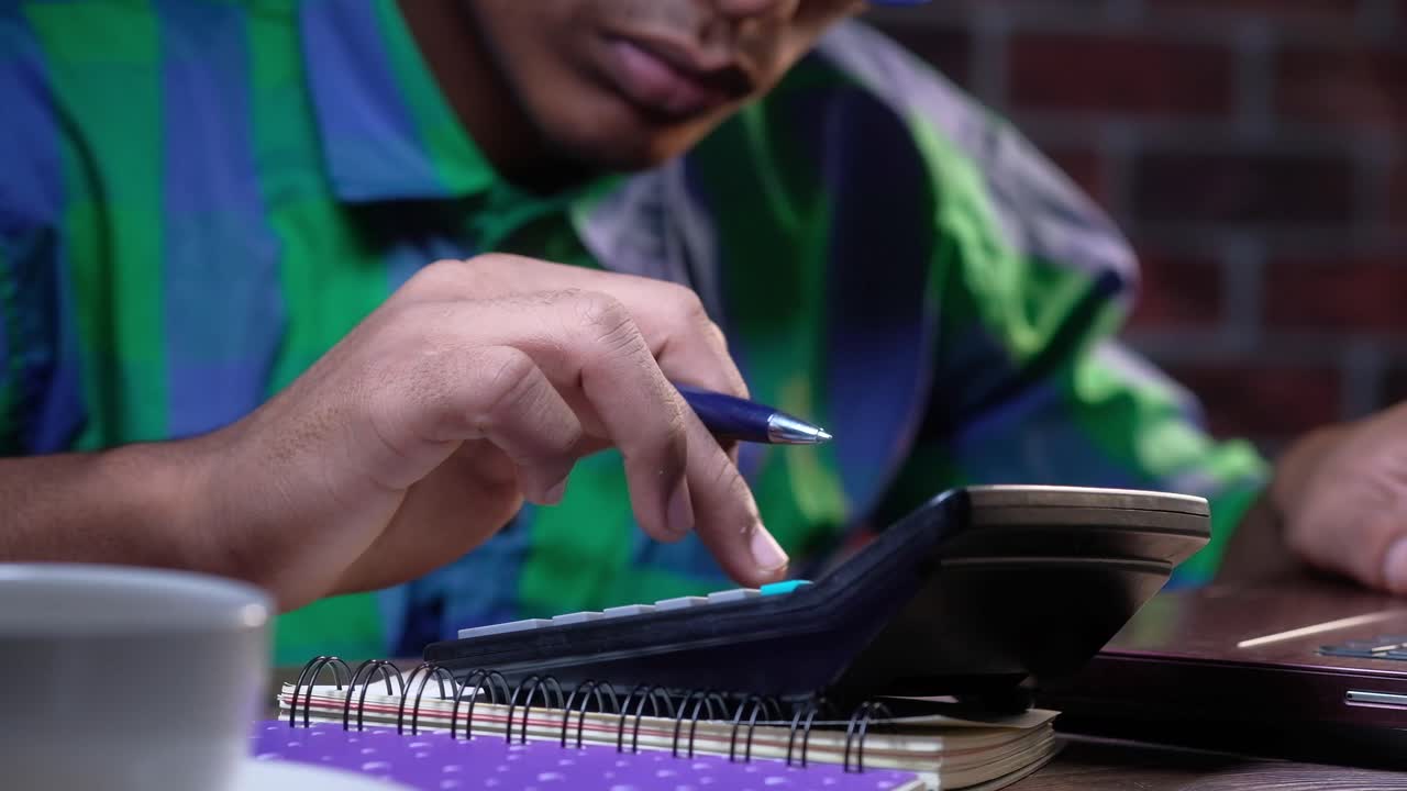 Man Working on Calculator at Night