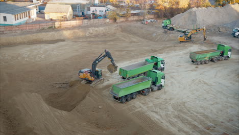 dump truck positioning for excavator to load dirt for transport. groundwork before the actual building process begins. heavy machinery, including excavators and dump trucks, work together to move dirt