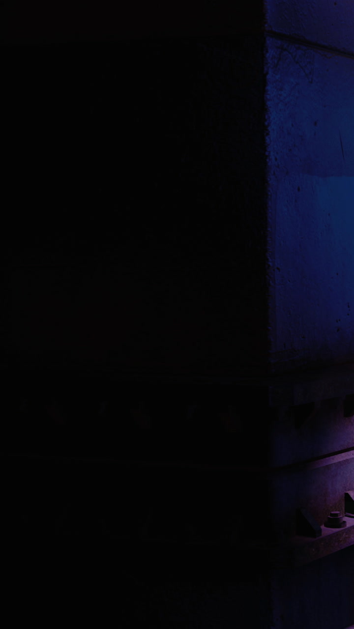 Red light shines on wall in dark space at night near urban area