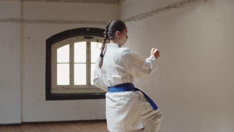 tracking shot of focused girl performing karate movements