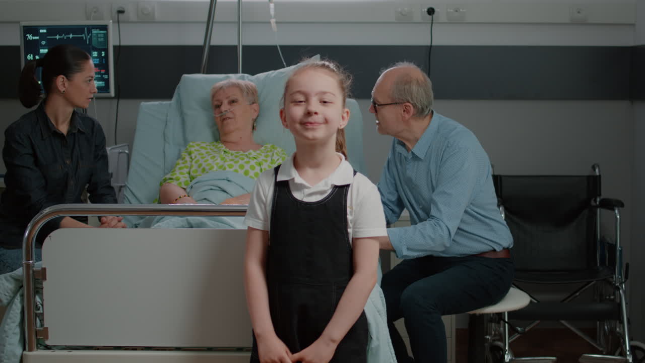 Portrait of child visiting senior woman in hospital ward with mother