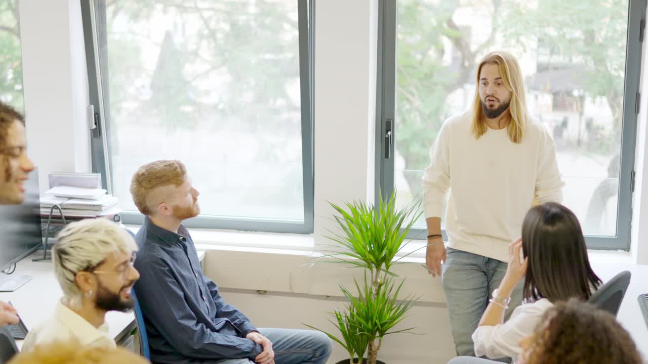 Ung mand, der taler under et forretningsmøde i et coworking-område