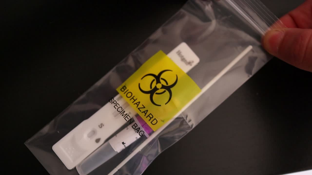 코비드 테스트의 잔여물을 폐기용 특수 백에 넣고 클로즈업 샷