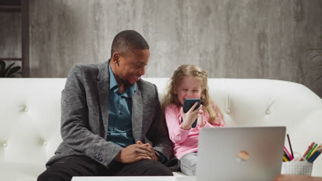 girl shows photos on phone to african-american teacher