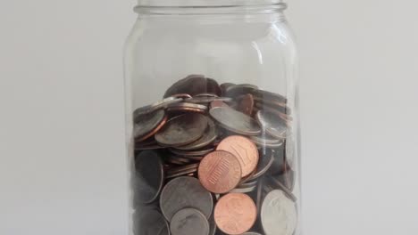 coins pile up in a jar to indicate savings