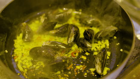 the cook cooks mussels in the pan