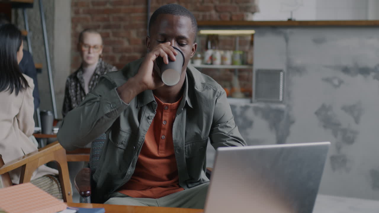 Man Working on Laptop in a Cafe