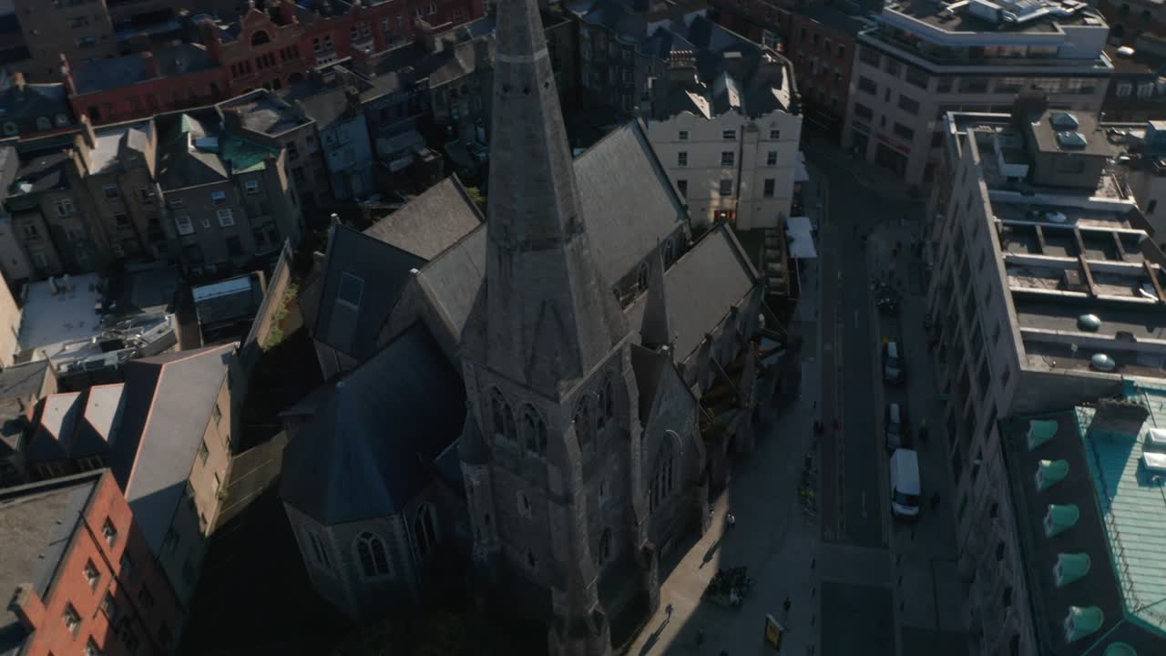 orbita tomada alrededor de la vieja iglesia de piedra. vista aérea de un edificio religioso con una aguja alta. dublín, irlanda