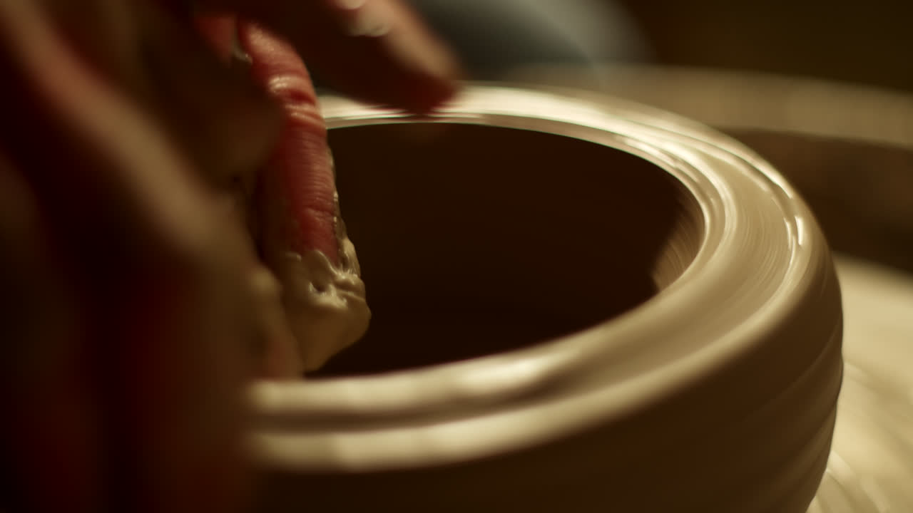 Close-up view of hands shaping clay on a pottery wheel
