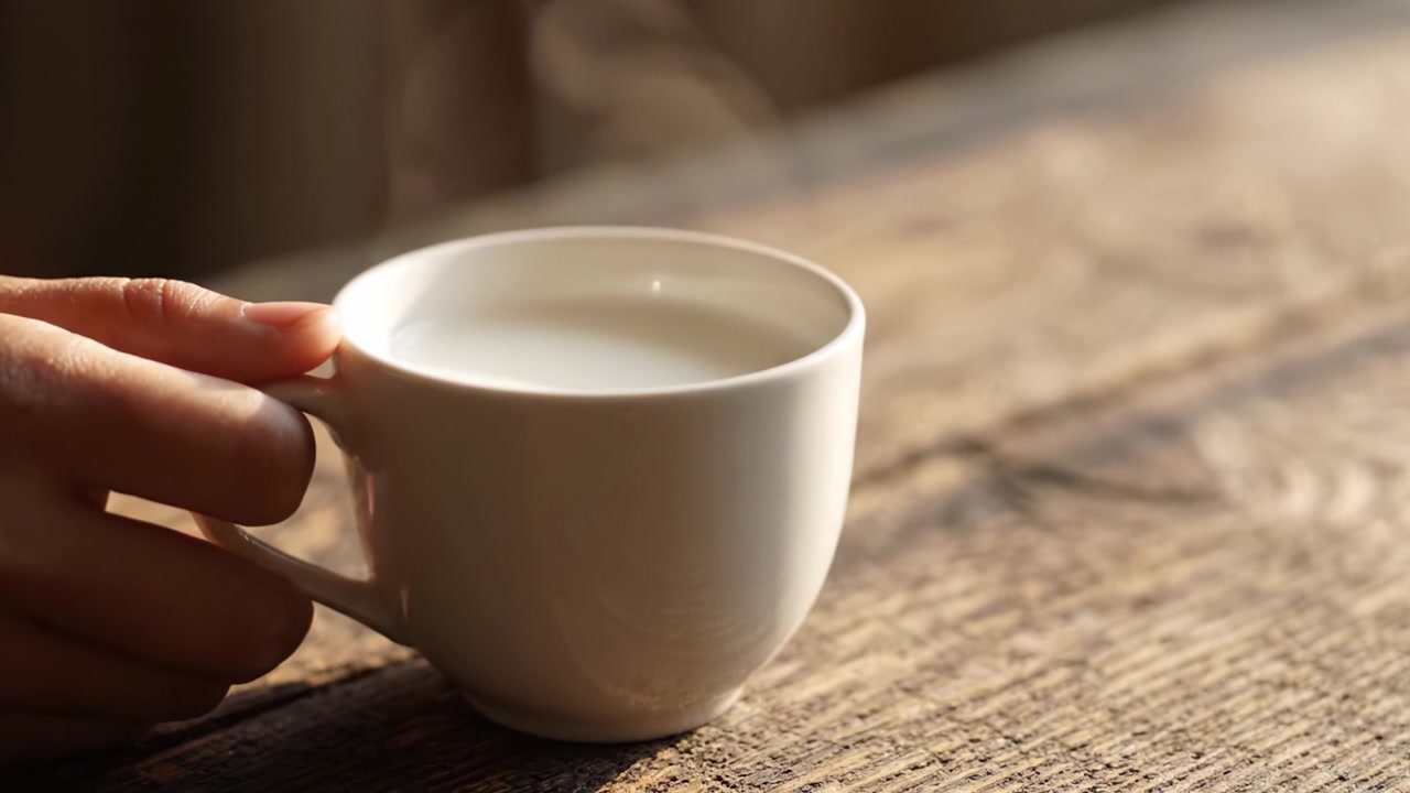 Et fredfyldt øjeblik: Nyder en varm kop kaffe på et rustikt træbord, omfavner komforten ved simple glæder i en rolig atmosfære
