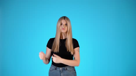 pretty blonde woman pointing with hands and fingers, presentation gesture, studio shot