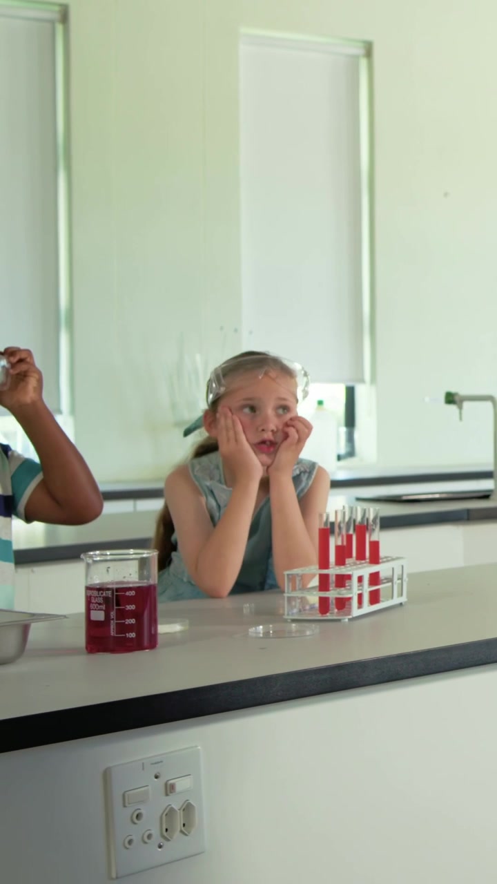 Adjusting goggles, striped boy moving across lab after prompt, answering with tube rack, copy space