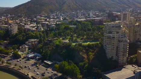 una carretera concurrida con una hermosa ciudad cerca de las montañas vista por vuelo de drones, tbilisi, georgia