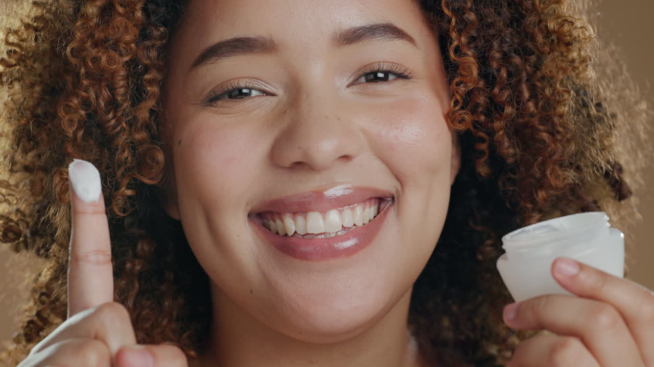 mujer negra, crema para el cuidado de la piel y cara con sonrisa