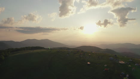 aerial flying over campers on top max patch mountain during sunrise