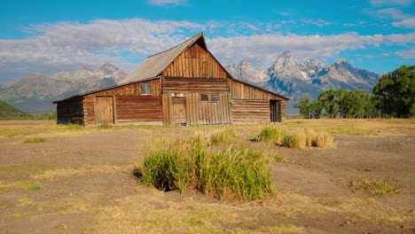 rustic wooden barn with grand teton mountains in background
