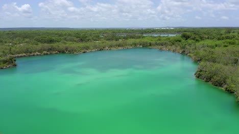 shot with drone at low altitude over the blue cap cana lake, cloudy sky, pleasant temperature for a dip