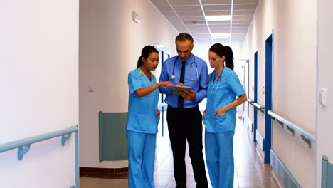 médico y enfermeras discutiendo en una tableta digital
