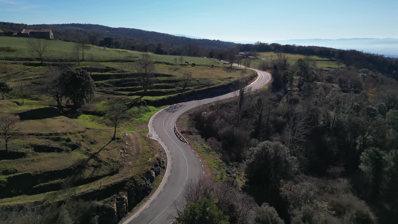 Strada tortuosa attraverso la campagna lussureggiante e verde di Tavertet, Barcellona, in una giornata limpida e soleggiata