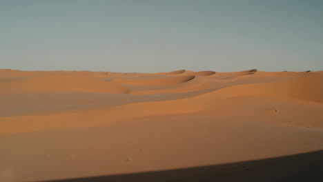 vast expanse of sandy desert dunes under a clear sky