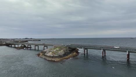 myrbaerholm bridge with atlantic ocean in background along the world famous atlantic ocean road in norway - panoramic aerial presenting bridge while moving gently forward and to left