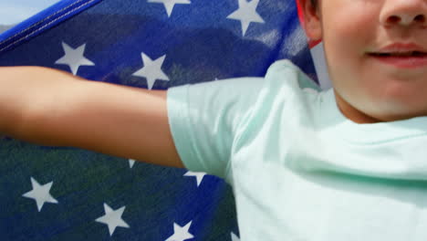 front view of caucasian schoolboy holding american flag in school playground 4k