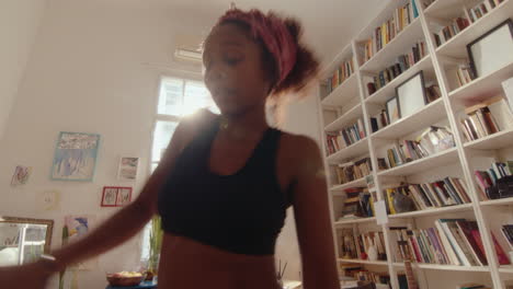 energetic black girl dancing with enjoyment at home
