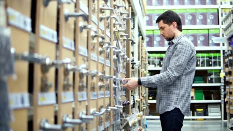 man shopping for door handles in a hardware store