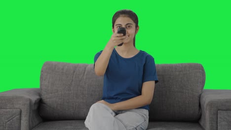 Happy-Indian-teenage-girl-watching-TV-Green-screen