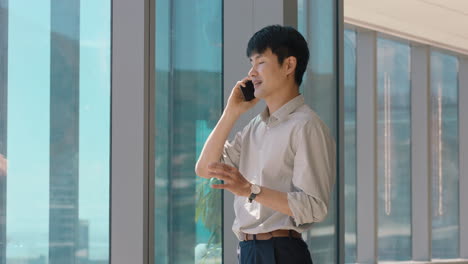 asian-businessman-using-smartphone-chatting-to-client-financial-advisor-negotiating-business-deal-corporate-sales-executive-sharing-expert-advice-having-phone-call-in-office-looking-out-window